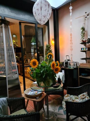 拉罗谢尔La Belle Amarre-Bed and Breakfast-Maison d'Hôtes的客厅配有带向日葵的桌子