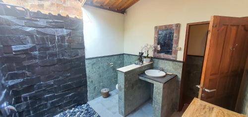 乌布乌布江左别墅的一间带水槽和石墙的浴室