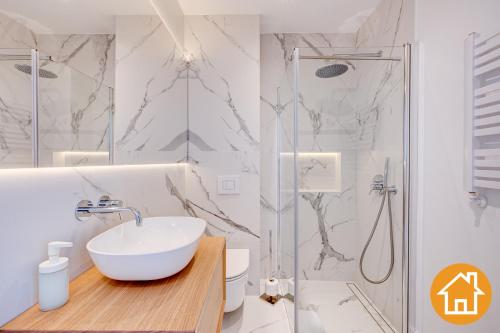 米兹多洛杰Apartamenty Marea - visitopl的白色的浴室设有水槽和淋浴。