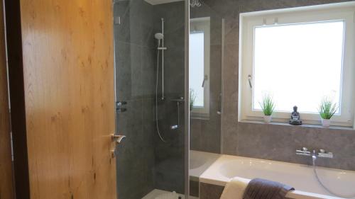 绍滕斯Chalet Hackl的带淋浴、浴缸和盥洗盆的浴室