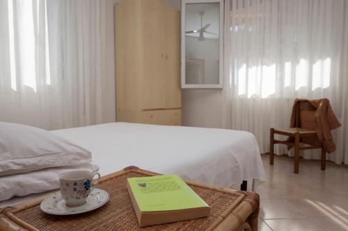 卡瓦利诺Appartamenti Giardino al Mare的一间卧室配有一张带桌子和书的卧室