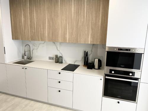 伊万诺-弗兰科夫斯克Caсtus Apartments 1的白色的厨房配有水槽和微波炉