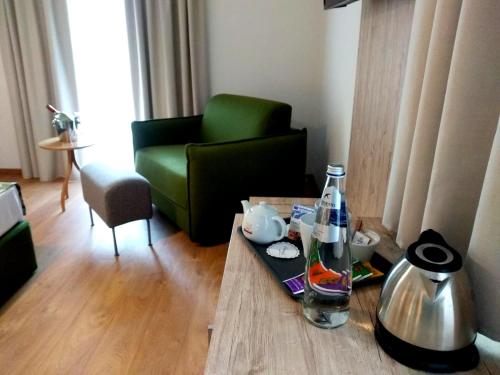 拉松迪索帕拉Hotel Kronplatzer Hof的客厅配有绿色沙发和桌子