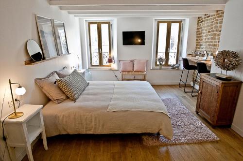 滨海布洛涅Meublé de tourisme, Les chambres du Beffroi的一间带大床的卧室和一间客厅