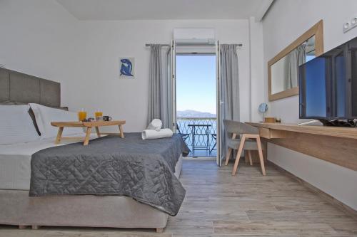 科孚镇Vidos Seaview Suite的一间卧室配有一张床、一台电视和一张桌子