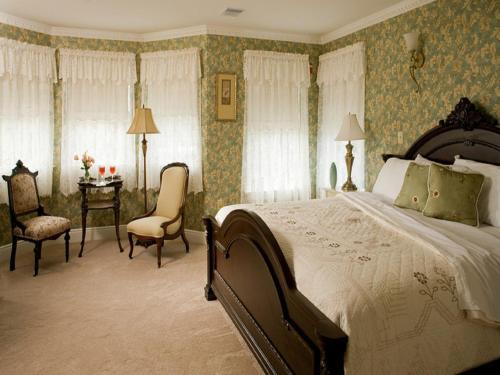 五月岬郡威尔布拉汉姆大厦酒店的卧室配有一张床和一张桌子及椅子