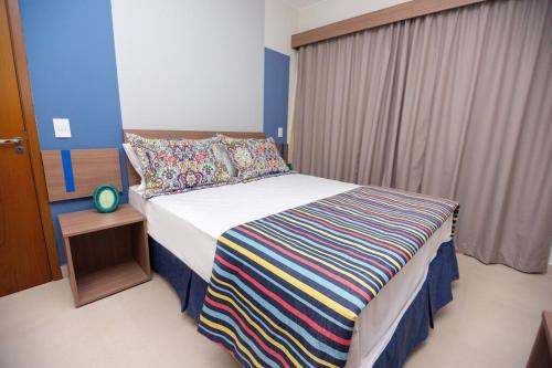 卡达斯诺瓦斯Alta Vista Thermas Resort的一间卧室配有一张带彩色条纹毯子的床