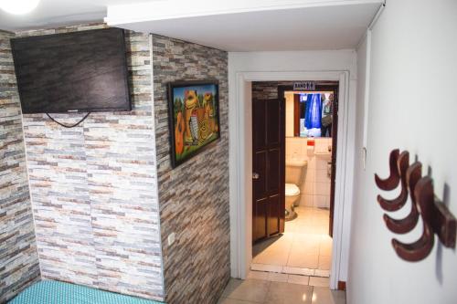 波哥大Hotel Punto 100的一间砖墙浴室和墙上的电视