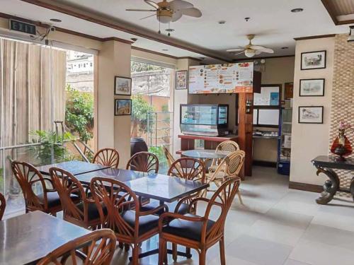 宿务RedDoorz Plus New Era Budget Hotel Mabolo former RedDoorz near Landers Superstore Cebu City的一间带桌椅和电视的用餐室
