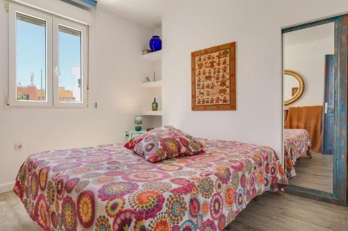 科拉雷侯Casa Agua的一间卧室配有一张带彩色毯子的床