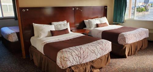 阿伯丁Olympic Inn & Suites的酒店客房设有两张床和窗户。