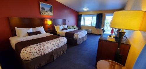 阿伯丁Olympic Inn & Suites的酒店客房,设有两张床和一盏灯