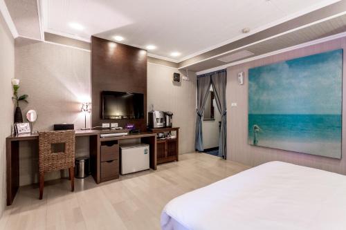 马公澎湖和田大饭店 的酒店客房配有一张床、一张书桌和一台电视。