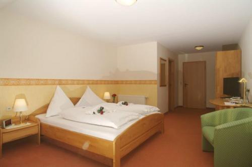 阿尔费尔德劳勃里博德斯格大地勇气酒店的一间卧室配有一张床、一张沙发和一把椅子