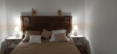 Mas-ThibertChambre d'hotes Mas Pékin的一间卧室配有一张床、两个床头柜和两盏灯。