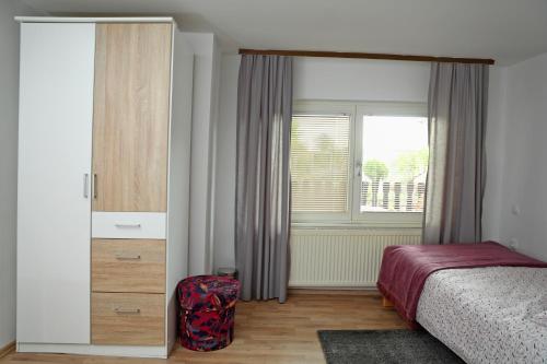 普图伊House Minka的一间卧室配有一张床、一个梳妆台和一扇窗户。