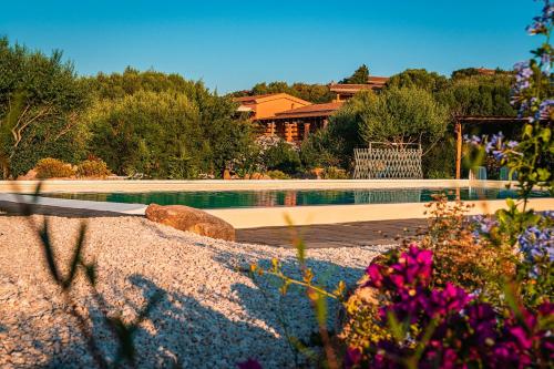 奥尔比亚Casagliana Suite Resort的鲜花庭院中的游泳池