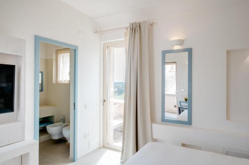 曼杜里亚Masseria Cuturi的白色的客房设有镜子和浴室