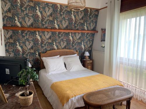 库尔瑟勒·苏尔·梅尔chambre normande的一间卧室配有床和壁纸覆盖的墙壁