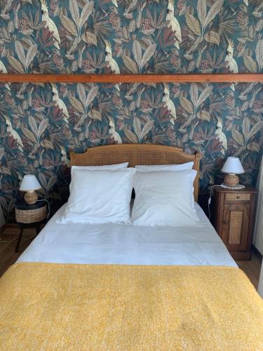库尔瑟勒·苏尔·梅尔chambre normande的一间卧室配有一张带花卉壁纸的床