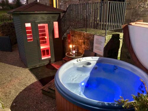 Stanton in PeakRomantic four poster Cottage private outdoor Hot Tub & Sauna at Harthill Hall plus private daily use of indoor pool and sauna 1 hour per day的游戏房前的按摩浴缸