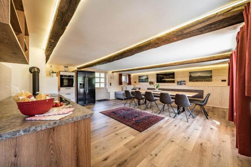奇勒谷地拉姆绍STAUDACH - Alpinresidenz Zillertal的开放式厨房以及带柜台和椅子的客厅。