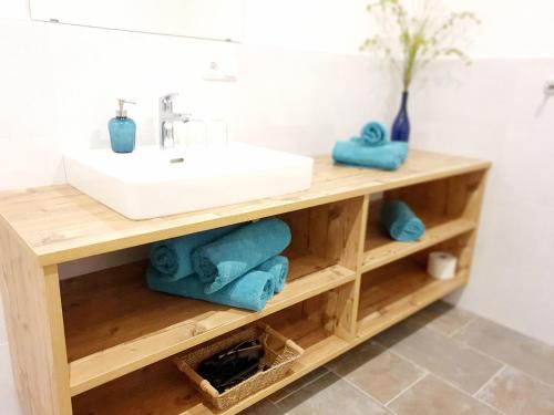 阿特湖莱特纳酒店的木制架子上配有水槽和毛巾的浴室