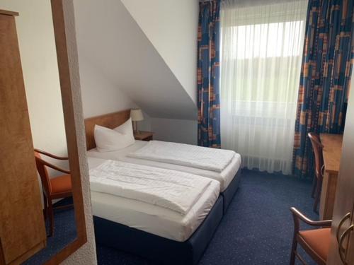 迪尔门杜梅纳霍夫宾馆的一间小卧室,配有床和窗户