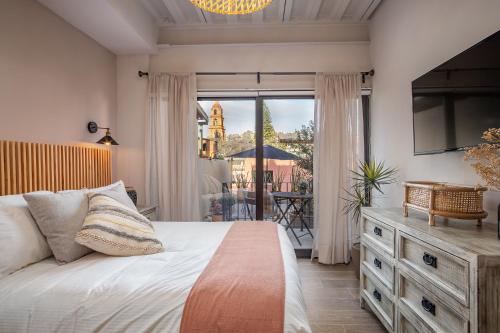 圣米格尔-德阿连德Casa Pandurata Luxury Apartments in Centro, San Miguel de Allende的一间卧室配有一张床,阳台配有桌子