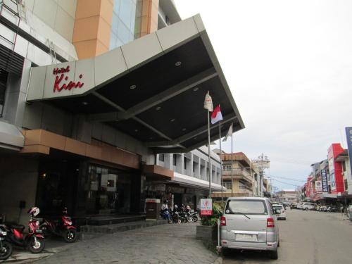 坤甸坤甸基尼酒店的停在大楼前的汽车