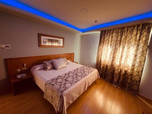 下卡尔瓦拉萨Hotel Cies的一间卧室配有一张蓝色天花板的床