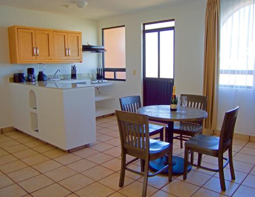 卡波圣卢卡斯Sunrock Hotel & Suites的厨房以及带桌椅的用餐室。