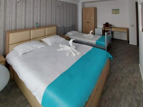 北马马亚-讷沃达里Armsea Mamaia Nord的一间卧室配有两张床和白色毛巾。