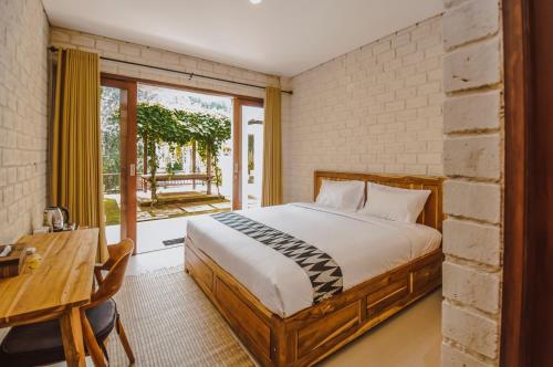 珀尼达岛The Lokal Penida by Nagisa Bali的一间卧室配有一张床、一张桌子和一个窗户。