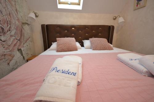 兹拉蒂博尔Zlatibor Hills PRESIDENT的一间卧室配有粉红色的床和毛巾