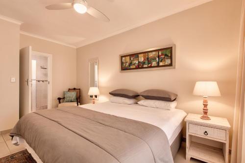 赫罗德斯湾Perlemoen Retreat的卧室配有一张大床,墙上挂有绘画作品