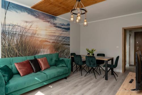 乌斯特卡Aquarius Baltico Apartment的客厅配有绿色沙发和桌子