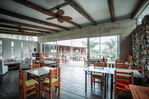 拉帕洛马Altos de la Serena Apart Hotel的餐厅配有桌椅和吊扇