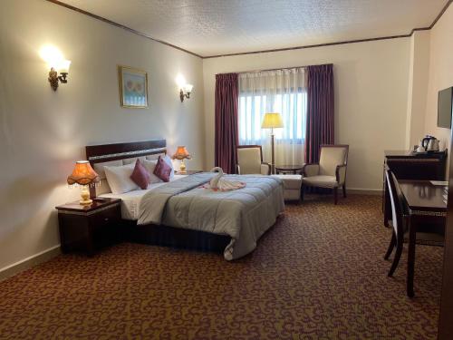 蒙罗维亚Boulevard Palace Hotel的配有一张床和一张书桌的酒店客房