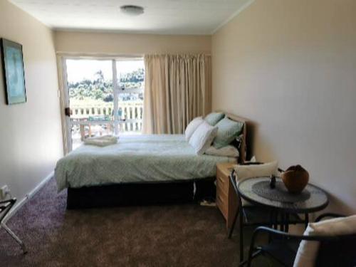Days BayBreakaway at York Bay的一间卧室配有一张床、一张桌子和一个窗户。