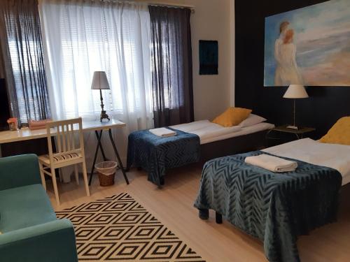 皮耶克赛迈基Wanha Neuvola Guesthouse & Apartment的一间设有两张床、一张桌子和一把椅子的房间