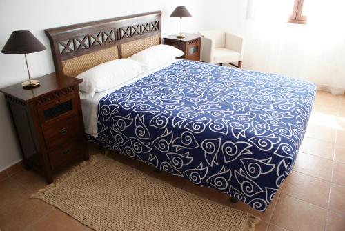 拉卡布雷拉乡村药房酒店的一间卧室配有一张带蓝色和白色床单的床。