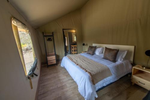 蒙塔古Grysbokkloof Private Nature reserve luxury Glamping 6km from Montagu的帐篷内一间卧室,配有一张大床