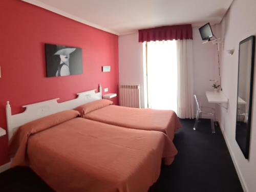 夫罗米斯塔HOTELSANMARTIN的红色卧室设有两张床和窗户