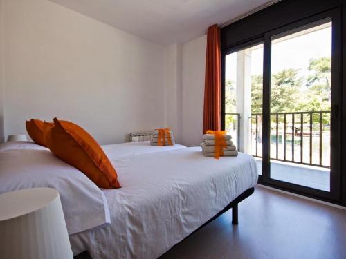菲格拉斯Soho Parc的一间卧室配有带橙色枕头的床和大窗户