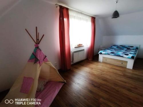 波拉齐克BIESCZADNIK的小房间设有床和窗户