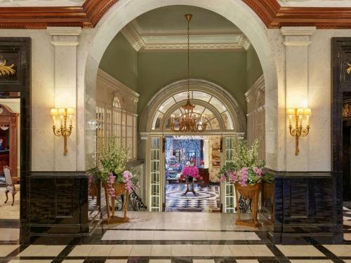 伦敦萨伏依酒店的大堂设有拱门,花瓶中鲜花盛开