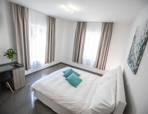 苏黎世Self Service Hotel Kernhof Langstrasse的卧室配有白色床和蓝色枕头