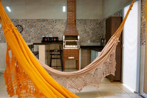 特林达迪Casa com 2 Quartos e Varanda Gourmet的带厨房的客房内的吊床