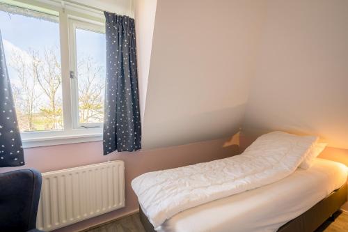 德瓦尔Nieuwlanderweg 61的一间小卧室,配有床和窗户